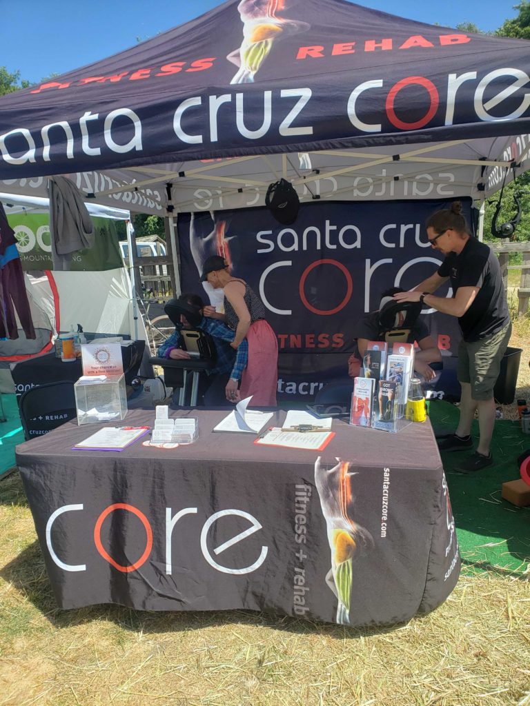 massage therapists allen and claudia at the santa cruz core booth with old cabin classic mountain bikers